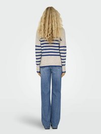 Streepjessweater in crème met blauwe horizontale strepen, gecombineerd met wijd uitlopende blauwe jeans. De trui heeft lange mouwen en geribbelde manchetten.
