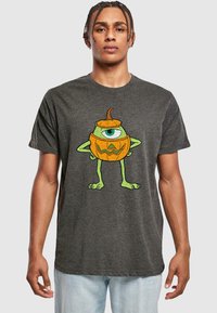 Grå bomulds t-shirt med et grafisk motiv af et grønt monster med et øje og et græskar-design, detaljeret med en orange top og et trekantet ansigt.