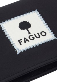 Zwart stoffen item met een wit rechthoekig label met een silhouet van een zwarte boom boven de merknaam "FAGUO" geborduurd met lichtblauwe draad.