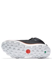 Chaussure noire avec une tige texturée, semelle extérieure en caoutchouc blanc présentant un motif de semelle rigoureux, et accents de marque rouge et vert.