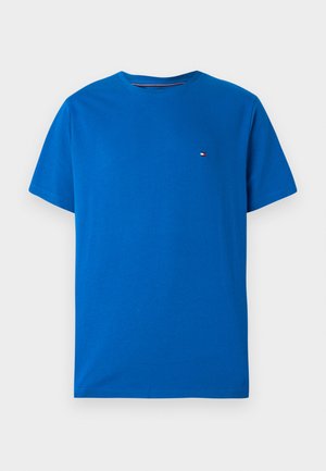 T-shirt bleu à manches courtes en coton, avec un col rond et un petit logo brodé sur la poitrine gauche. Texture lisse et coupe décontractée.