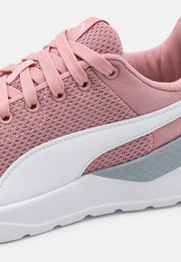 Sneaker rosa in rete con lacci piatti, dettagli bianchi e grigi, punta arrotondata, particolari testurizzati e suola imbottita per il comfort.