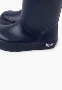 Černé gumové deštníkové boty s hladkým povrchem, kulatou špičkou, texturovanou černou podrážkou a malou nálepkou "igor" po straně.