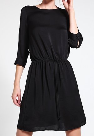 Robe noire avec des manches 3/4, taille élastique et détail à cordon. Fabriquée en tissu lisse, avec un col rond et une coupe décontractée.