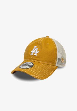 Mustard yellow and white mesh baseball cap with white "LA" logo and a curved brim with distressed details. Adjustable fit with brand sticker on brim.