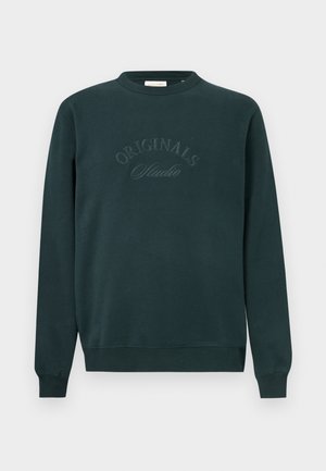Temno zeleno sweatshirt z dolgimi rokavi, okroglim ovratnikom in vezenim napisom "ORIGINALS Studio" spredaj. Mehka tekstura tkanine.