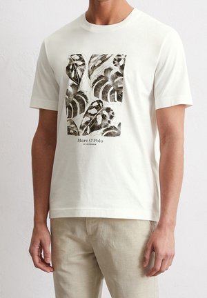 Hvid bomulds t-shirt med et grafisk mønster af sorte og grønne blade, med "Marc O'Polo" tekst nederst til branding. Korte ærmer.