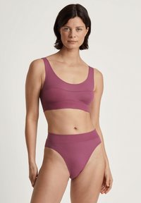 Lila gerippte Bralette mit breiten Trägern und einem elastischen Bund, kombiniert mit passenden hochgeschnittenen Bikinihosen. Weicher, dehnbarer Stoff.