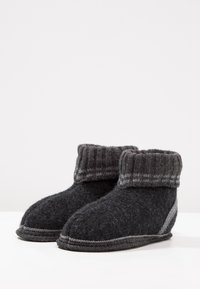 Zwarte en grijze vilten slippers met een geribde rand, ronde neus en contrasterend stiksel langs de zool en zijkant. Zachte structuur overal.