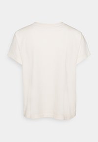 Camiseta blanca de algodón con mangas cortas, corte relajado y escote redondeado. Textura suave, sin patrones ni acentos visibles.