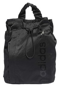 Black drawstring bag made of nylon with a glossy black "adidas" logo and a textured finish. Features a scrunched handle and attached logo tag.