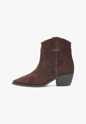 Bruine suède enkellaars met spitse neus, korte gestapelde hak, decoratief geperforeerd ontwerp en een trekhaak aan de achterkant voor gemakkelijk aan- en uittrekken.