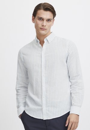 Camisa de manga larga a rayas en azul claro y blanco con cuello abotonado. Hecha de un tejido texturizado, presenta un dobladillo curvado y cierre de botones.