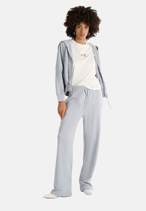 Ensemble de vêtements de sport gris clair comprenant un hoodie zippé et un pantalon à cordon, tous deux en tissu doux avec une coupe décontractée et des accents de logo.