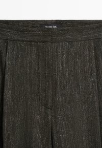 Tmavě šedé texturované kalhoty s puky a pasem, s viditelnou značkovou etiketou Massimo Dutti.