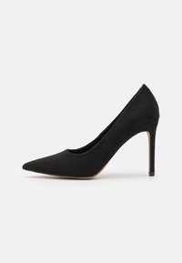 Pompe à talon haut en daim noir avec un bout pointu, un design élégant, un talon aiguille fin et une texture lisse. Aucun motif ou accent visible.