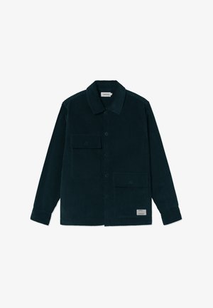 Donkergroene corduroy overhemdjasje met knoopsluitingen, twee klepzakken aan de voorkant en een stoffen label nabij de onderzoom.