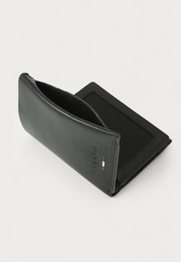 Portefeuille en cuir noir avec texture lisse, design épuré, emplacement pour cartes à l'intérieur et détail de logo en relief sur la surface extérieure.