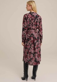 Blumenkleid mit langen Ärmeln aus dunklem Stoff, verziert mit rosa und burgunderfarbenen Blumenmustern; tailliert mit einem Faltenverschluss auf der Rückseite für eine schöne Silhouette.
