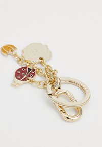 Porte-clés avec des maillons en métal doré, orné de charms représentant une coccinelle, une rose et une forme jaune. Surface lisse, motifs détaillés et accents.