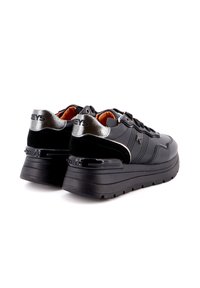 Sneaker nere con tomaia in materiale misto che presenta dettagli lucidi e una suola nera spessa. Dettagli in argento sul tallone e sulla linguetta.