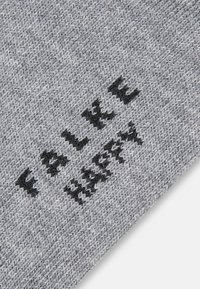 Prim-plan al unei țesături tricotate gri cu text negru "WALK PROMISE" tricotat în material.