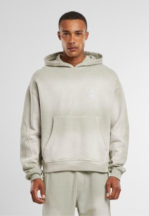 Light gray oversized hoodie in soft cotton blend, featuring a front pocket, drawstring hood, ribbed cuffs, and detailed stitching.