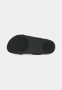 Καφέ σανδάλι με υφασμένη μαύρη λαστιχένια σόλα και δύο ρυθμιζόμενους ιμάντες. Η σόλα διαθέτει κυκλικά αντιολισθητικά μαξιλαράκια για καλύτερη πρόσφυση.