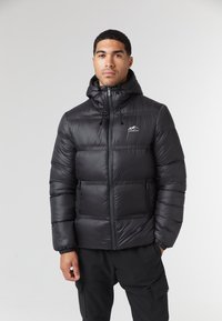 Giacca nera imbottita con colletto alto, cappuccio regolabile, zip e tasche, caratterizzata da una superficie liscia e lucida e un logo in contrasto.
