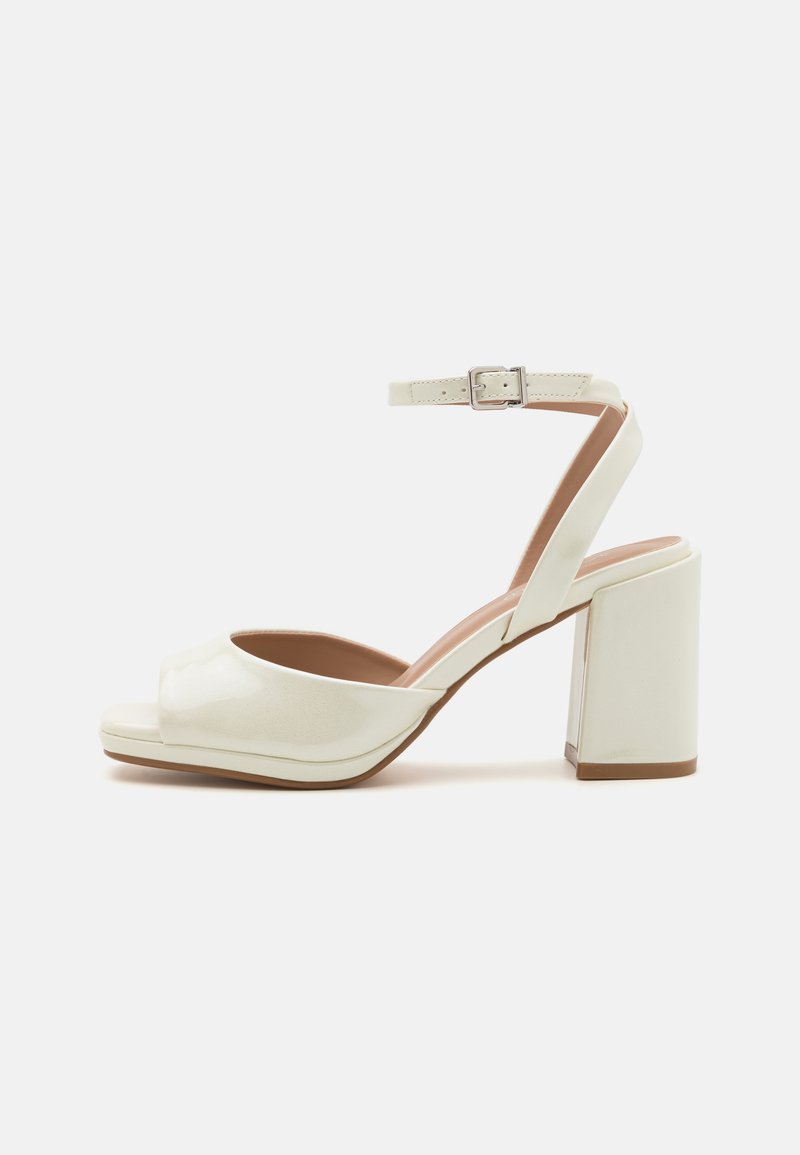 Weiße offene Absatzsandalen mit glänzender Oberfläche, verstellbarem Knöchelriemen und quadratischem Blockabsatz. Glatte Textur und minimalistisches Design.