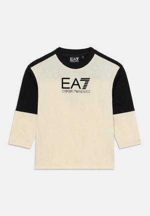 Kremfarget og svart langermet T-skjorte med rund hals. Har 'EA7 Emporio Armani' logo i svart. Laget av mykt bomullsmateriale.