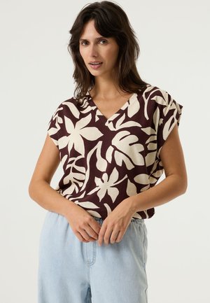 Top de manga corta con cuello en V en color granate con un gran estampado floral en crema; ajuste relajado; tela suave; combinado con pantalones holgados de color azul claro.