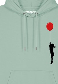 Muntgroene hoodie met een voorzak, met een zwart silhouet van een kind dat een rode ballon vasthoudt als ontwerp-element.