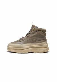 Zapatilla alta con parte superior de cuero beige, mediasuela gruesa color crema, suela estriada y un discreto logotipo de PUMA en el lateral.