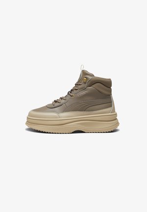 High-top sneaker with a beige leather upper, thick cream midsole, ridged outsole, and subtle PUMA branding on the side.