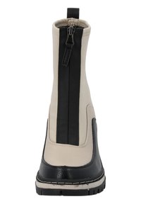 Botines beige y negros con un acabado suave, que cuentan con una cremallera trasera, suela texturizada y un acento negro contrastante en la punta.