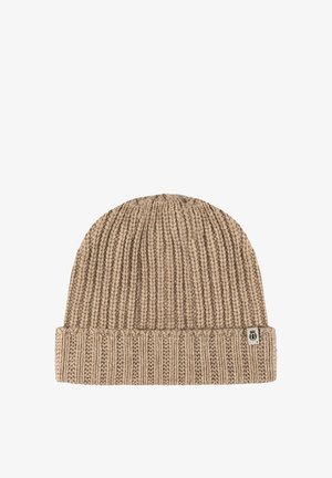 Beige ribbed knit beanie with a folded cuff and a small rectangular fabric tag on the cuff’s right side.