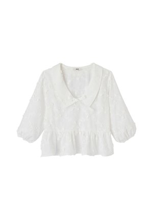 Blouse blanche avec motif floral texturé, col large, manches ballon trois-quarts et détail volanté à la taille.