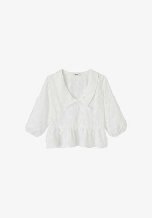 Blouse blanche avec motif floral texturé, col large, manches ballon trois-quarts et détail volanté à la taille.