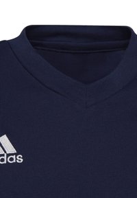 Navy blue athletic shirt made of stretchy fabric, featuring a V-neck collar and a white embroidered logo on the left chest.