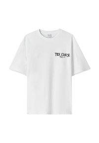 T-shirt bianca in cotone con maniche corte e scollatura rotonda. Presenta una scritta nera "TIDE CHASE" sul davanti.