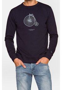 Sweatshirt marine en coton avec un col rond, comportant un graphique de bicyclette blanche et un logo imprimé sur le devant, des poignets et un ourlet côtelés.