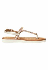 Sandales plates avec un dessus en cuir beige, présentant des sangles décoratives avec un éclat métallique, un coussin de pied marron et une semelle en caoutchouc blanche.