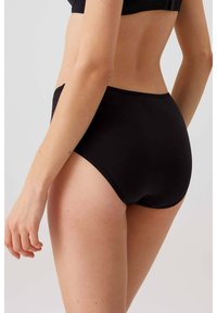 Hooggeplaatste zwarte slipjes van gladde stof, met een naadloos ontwerp en minimalistische details, gezien vanuit een zijaanzicht.