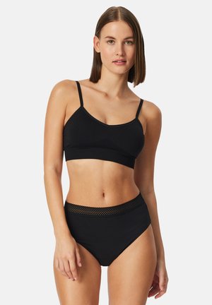 Black bralette with thin straps and a smooth texture; paired with high-waisted black panties featuring a mesh-accented waistband.