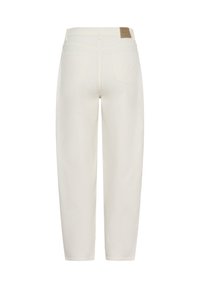 Un pantalon en denim blanc présente une coupe décontractée avec des poches arrière et une étiquette en cuir marquée à la taille. Texture lisse avec un design à jambe droite.