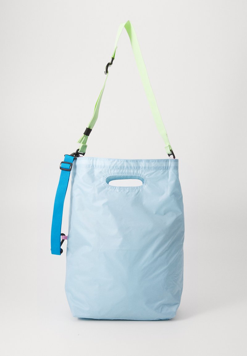 Φωτεινό μπλε ελαφρύ σακίδιο με υφή, διαθέτει επάνω χερούλι και ρυθμιζόμενους ιμάντες σε πράσινο και μπλε χρώμα.