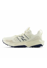 Baskets blanc cassé avec tige en mesh et daim, semelle épaisse géométrique, semelle extérieure noire, languette de traction, et logo "N" noir sur le côté.