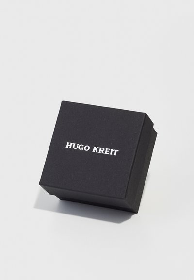 Svart pappgaveeske med lokk, med hvit tekst "HUGO KREIT" på toppen. Enkel rektangulær form, matt tekstur.
