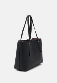 Zwarte leren tote bag met een gestructureerde, rechthoekige vorm. Voorzien van dunne, langwerpige handvatten en subtiele accenten van goudkleurig beslag.